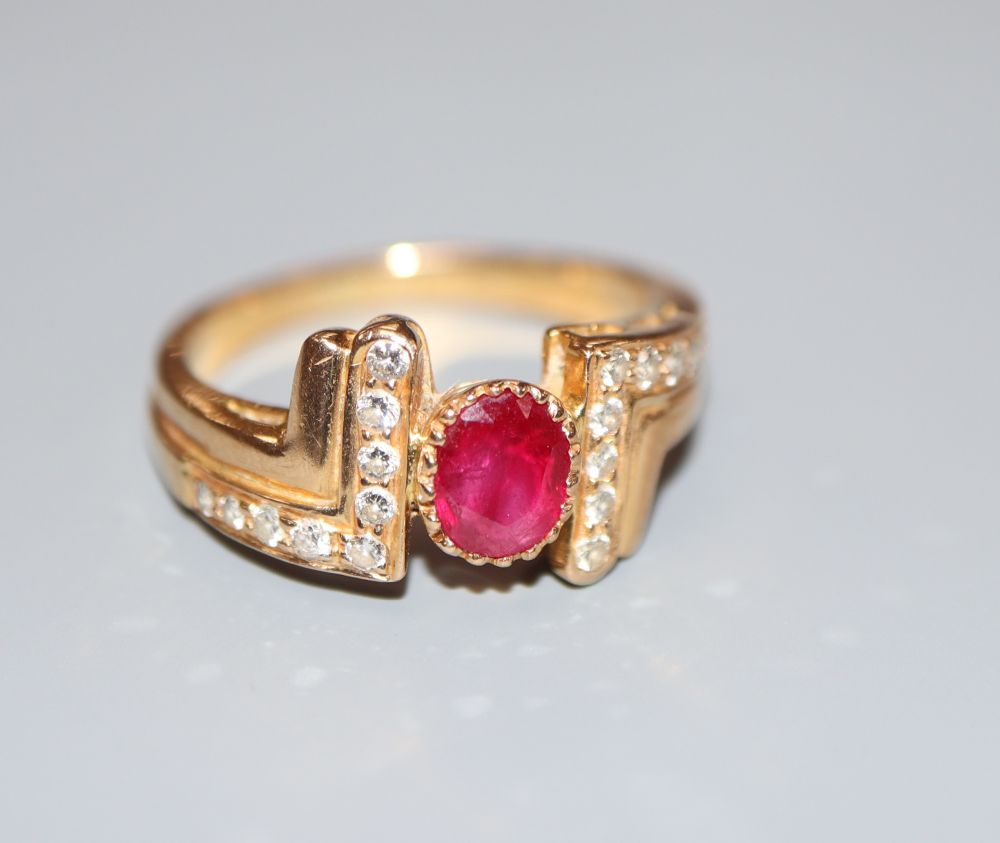 A modern 750 yellow metal, ruby and diamond dress ring, size M, gross 4.8 grams.